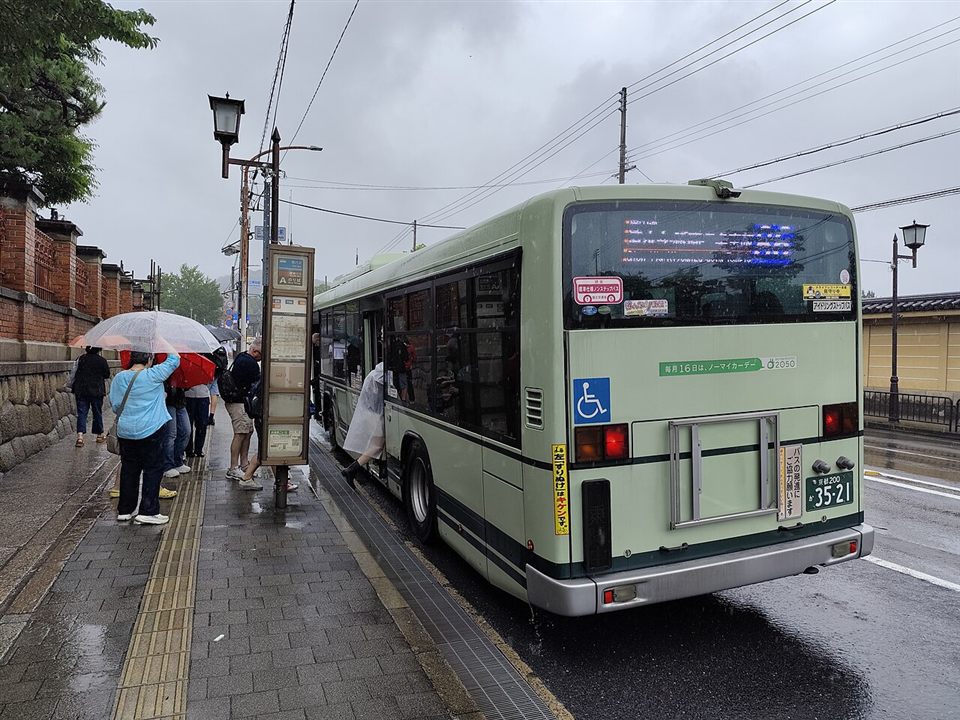 京都市バスの乗り場で中扉から乗る人たち（七条通）